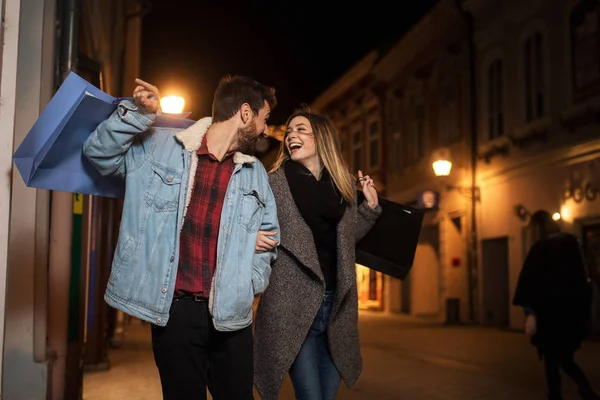 Close-up van een jong stel winkelen in de stad 's nachts — Stockfoto