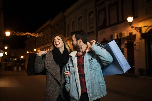 Primer plano de una joven pareja de compras en la ciudad por la noche — Foto de Stock