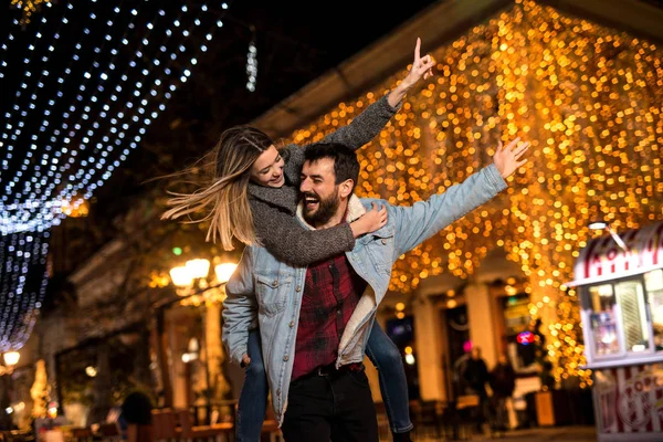 Joven pareja feliz pasar un buen rato por la noche en una gran ciudad — Foto de Stock