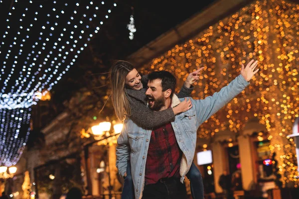 Genç ve mutlu bir çift büyük bir şehirde gece iyi vakit geçiriyor. — Stok fotoğraf