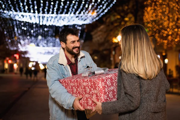 Різдвяний подарунок, щаслива пара з різдвяним та новорічним подарунком на вулиці — стокове фото