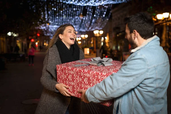 Regalo de Navidad, feliz pareja con regalo de Navidad y Año Nuevo en la calle — Foto de Stock