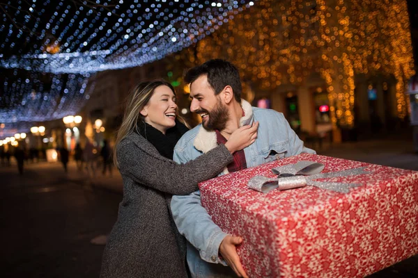 Χριστουγεννιάτικο δώρο, ευτυχισμένο ζευγάρι με τα Χριστούγεννα και το Νέο Έτος δώρο στο δρόμο — Φωτογραφία Αρχείου