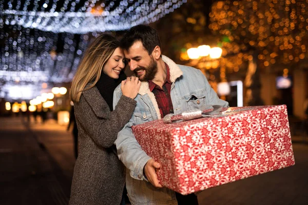 Різдвяний подарунок, щаслива пара з різдвяним та новорічним подарунком на вулиці — стокове фото