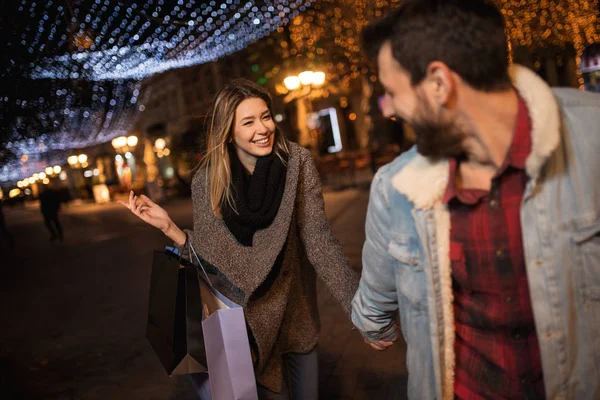 Retrato de una pareja con bolsas de compras en la ciudad mientras camina por la ciudad — Foto de Stock