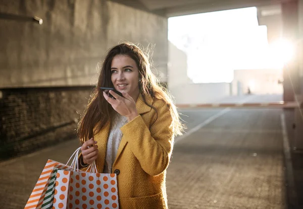 Mujer joven usando el móvil después de comprar — Foto de Stock