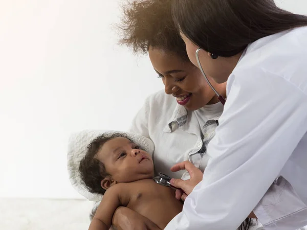 Aziatische Dokter Controleert Afrikaanse Baby Jongen Moeder Armen Gezondheidszorg Voor Stockfoto
