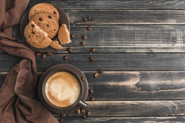 Koyu ahşap arka planda yulaflı köpüklü bir fincan kahve.