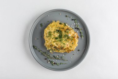 Beyaz sırtlı gri tabakta peynirli fırında domuz ve kekik.