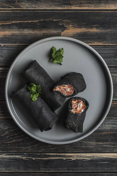 Mehrere schwarze Tintenfischpfannkuchen mit Lachs und Käse fil — Stockfoto