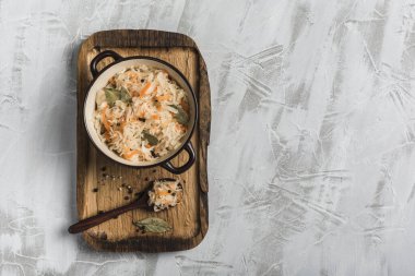 Tahta tepside bir tabakta mayalanmış lahana ve arka planda bir kaşık. Üst Manzara. Kopyalama. Yatay oryantasyon. Düz yatıyordu.