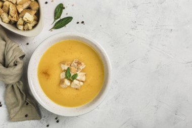 Balkabağı ve havuç çorbası kremalı ve ıspanak ve ekmek kırıntıları siyah zemin üzerinde tahta tahtalar olan siyah bir tabakta. Üst Manzara. Uzayı kopyala Dikey yönelim.