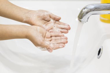 Çocukların elleri coronavirüs enfeksiyonunu önlemek için sabunla yıkanır. COVID-19 kavramı. Kapatın. Yatay yönelim.