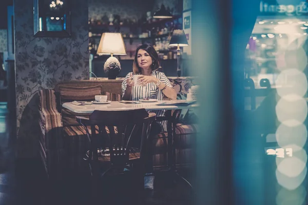 Portrait of a girl in the interior of a cafe with a Cup of coffee. Morning Breakfast in a coffee shop. Horizontal orientation with copy space.