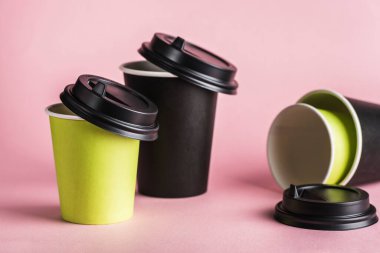 Biraz yeşil ve siyah kahve fincanı. Pembe arka planda kapakları var. Fotokopi alanına sıfır atık konsepti. Yatay yönelim.