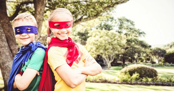 Brother and sister in cape and eye mask — Stock Photo, Image