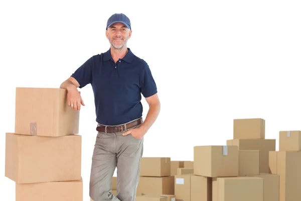 Delivery man leaning on pile of cardboard boxes — Stock Photo, Image