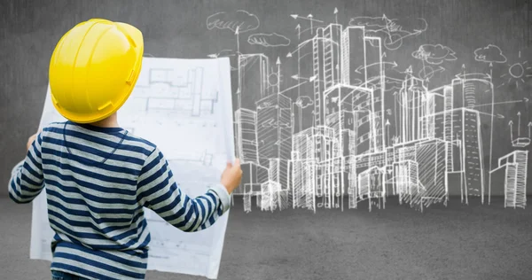 Boy in hard hat reading a plan — Stock Photo, Image