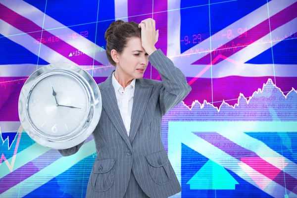 Расстроенная деловая женщина держит настенные часы — стоковое фото