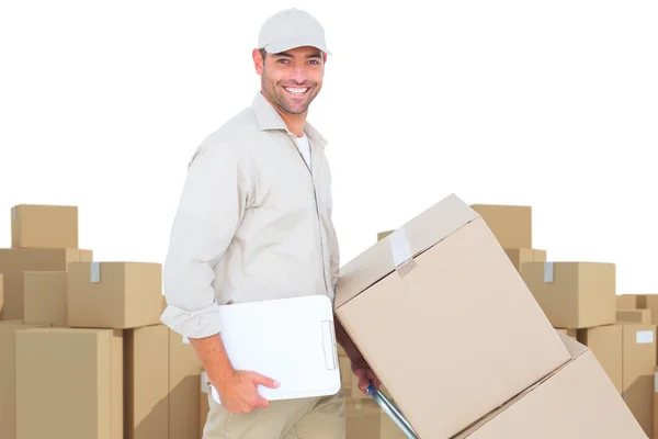 Delivery man pushing trolley of boxes — Stock Photo, Image