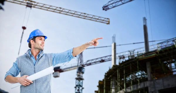 Arquitecto apuntando contra grúa y edificio Fotos de stock