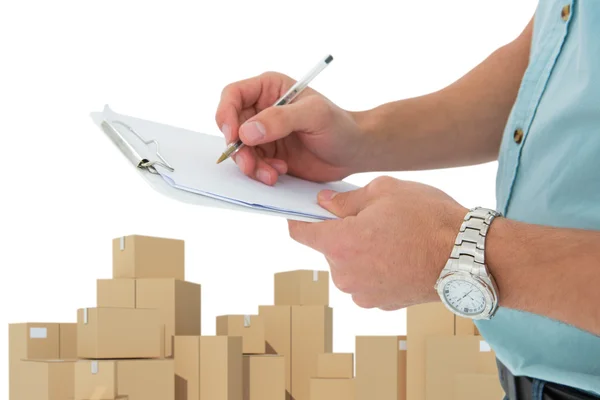 Delivery man writing on clipboard — Stock Photo, Image