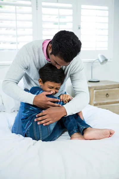 Père et fils jouant au lit — Photo