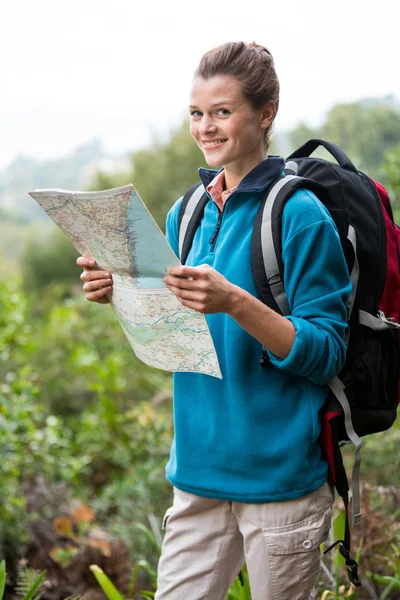 女性的徒步旅行者看着地图在森林里 — 图库照片