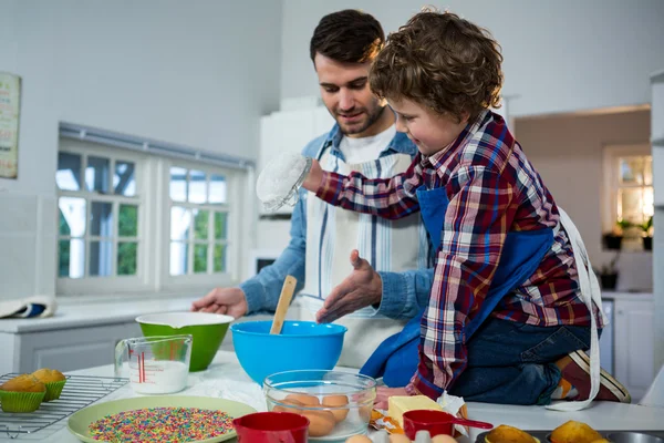 Padre insegnare a suo figlio come fare cupcake — Foto Stock