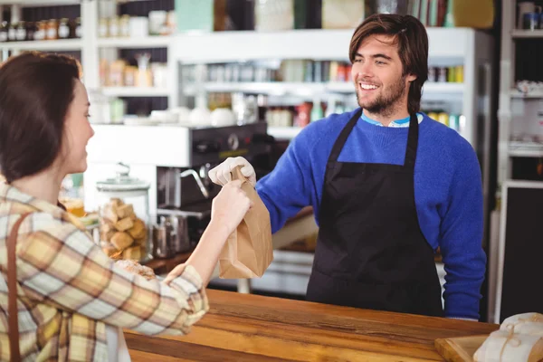 Waiter giving parcel to customer at counter — Stock Photo, Image