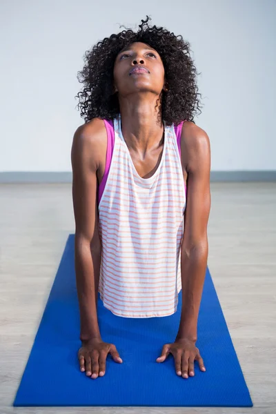 Woman doing cobra pose on exercise mat — Stock Photo, Image