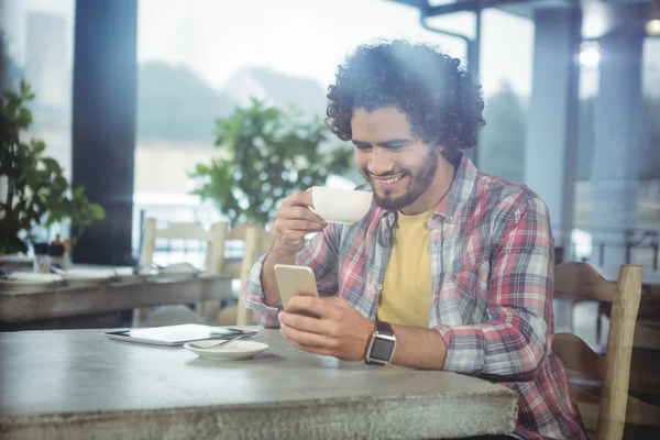 Man met behulp van de telefoon terwijl het hebben van koffie — Stockfoto