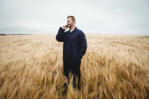 Фермер розмовляє на мобільному телефоні в полі — стокове фото