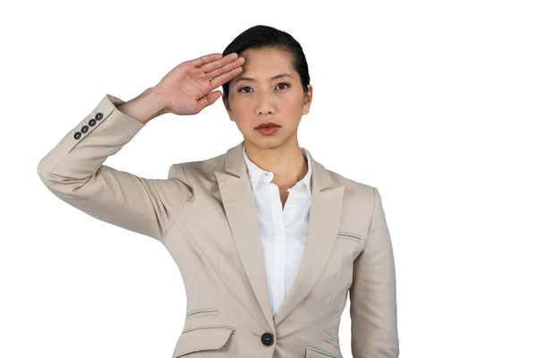 Businesswoman saluting against white background — ストック写真