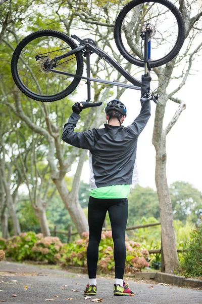 Cycliste homme portant un vélo de montagne — Photo