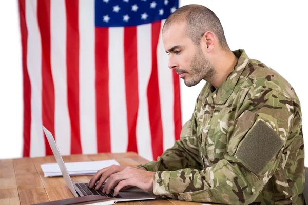 Soldat med en laptop på skrivbord — Stockfoto