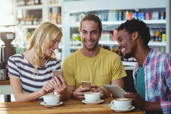 Drie vrienden met behulp van telefoons — Stockfoto