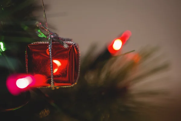 Luz de fada e pequena caixa de presente na árvore de Natal — Fotografia de Stock