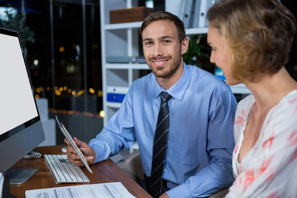 Affärsman som diskuterar med kollega över tablett — Stockfoto