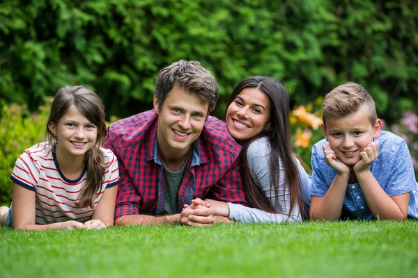 Lycklig familj ligger i park — Stockfoto