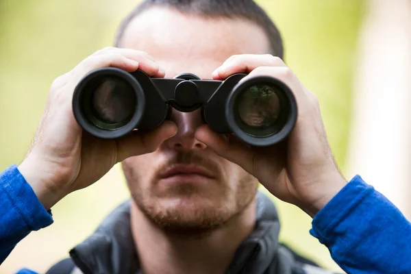 Escursionista maschio guardando attraverso il binocolo — Foto Stock