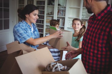 Family unpacking cartons together clipart