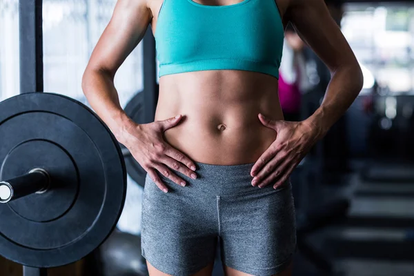 Female athlete touching belly in gym — Stock Photo, Image