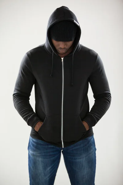 Spy in a hoodie standing against white — Stock Photo, Image