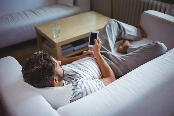 Muž pomocí svého mobilního telefonu v obývacím pokoji — Stock fotografie