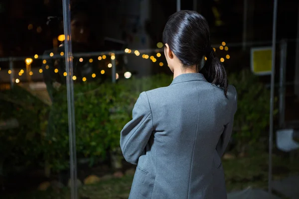 Affärskvinna tittar ut genom fönstret — Stockfoto