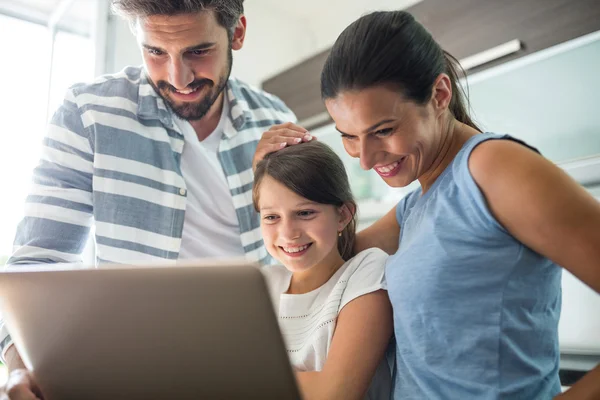 Famille heureuse en utilisant un ordinateur portable dans le salon — Photo