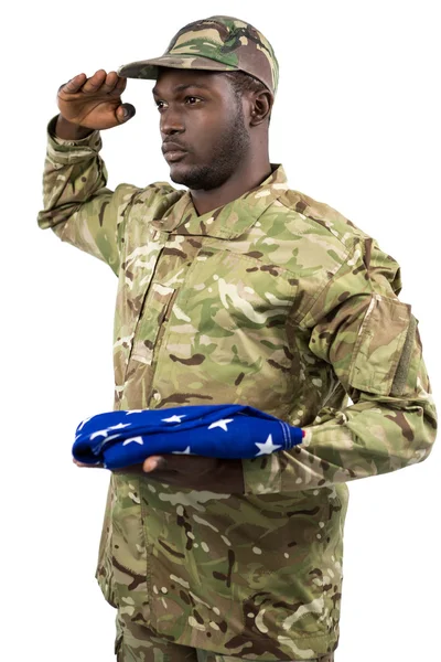 Soldado segurando uma bandeira americana e saudando — Fotografia de Stock
