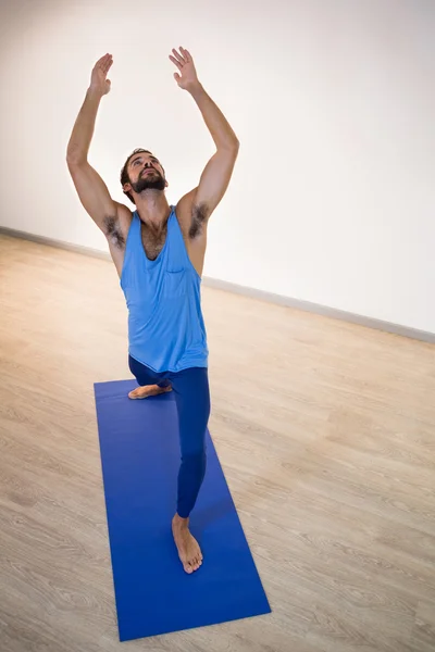 Man doing warrior pose on exercise mat — Stock Photo, Image