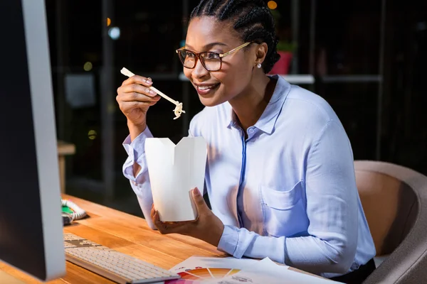 Affärskvinna äta nudlar på hennes skrivbord — Stockfoto